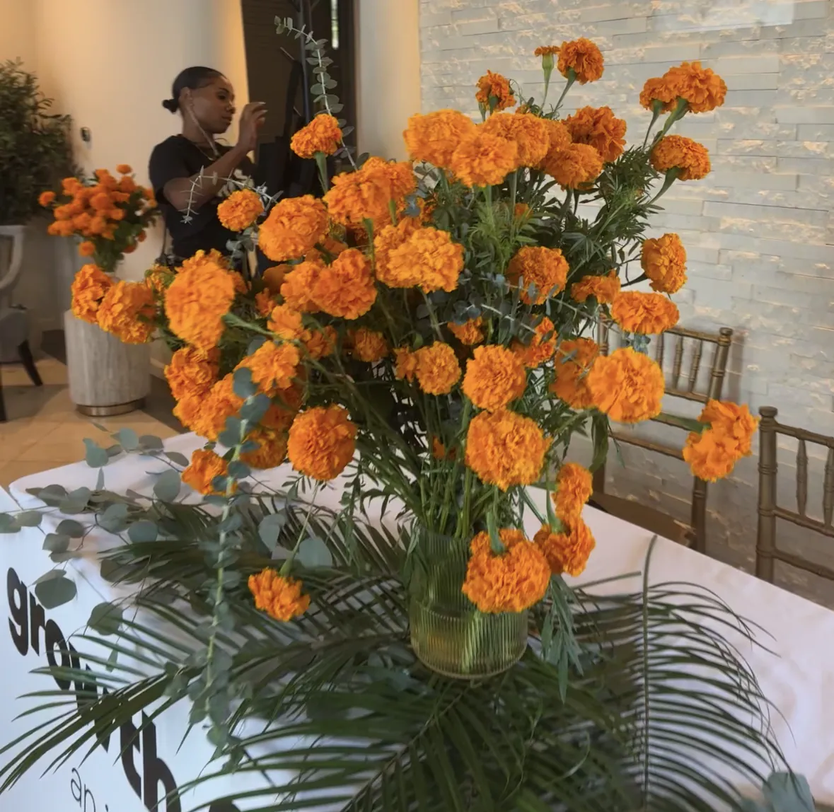 Jasmine styling marigold arrangements at a brand activation