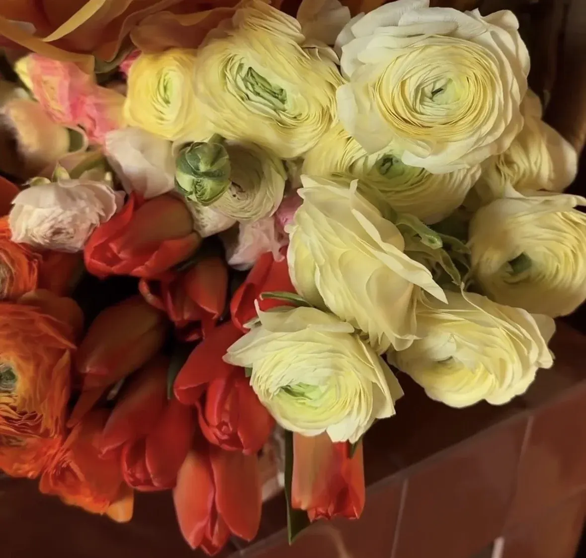 Cream ranunculus with orange tulips